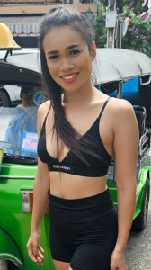Sexy TukTuk Patrol Ariana Arwen poses in tight shorts and sports bra in front of tuk