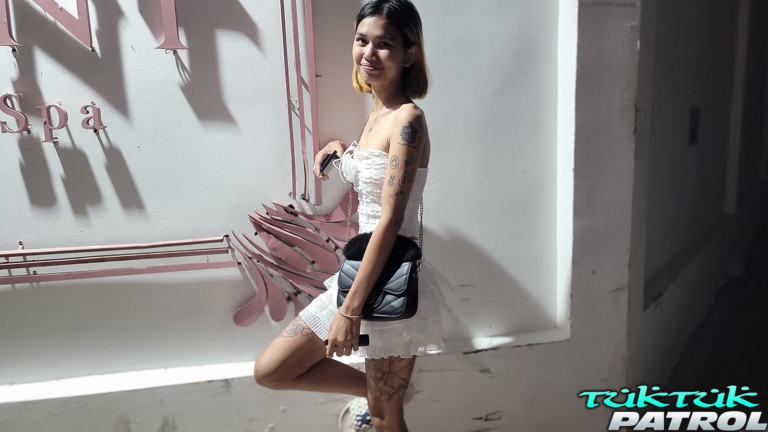 Posing next to building on sidewalk